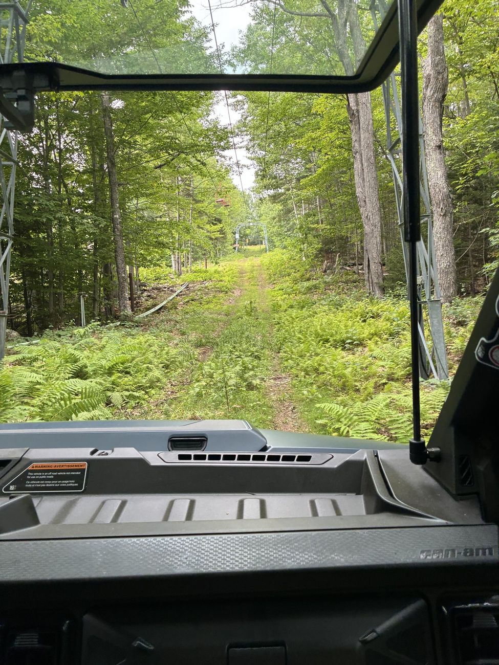 View from inside a UTV driving up a summer ski trail